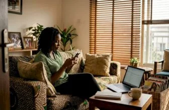 Nigerian woman using phone in living room
