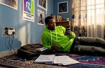 Nigerian youth browsing smartphone in home setting