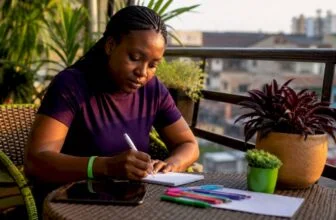 Nigerian woman writing citizen feedback at home desk