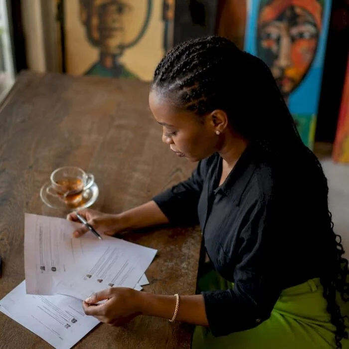 Nigerian woman moderating printed comments at desk
