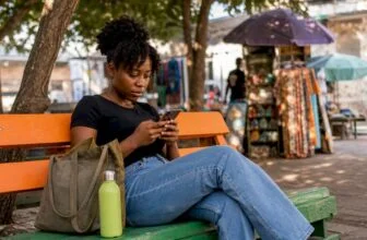 Nigerian woman using smartphone outdoors in market