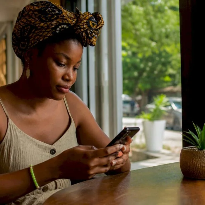 Nigerian woman completing online registration on phone