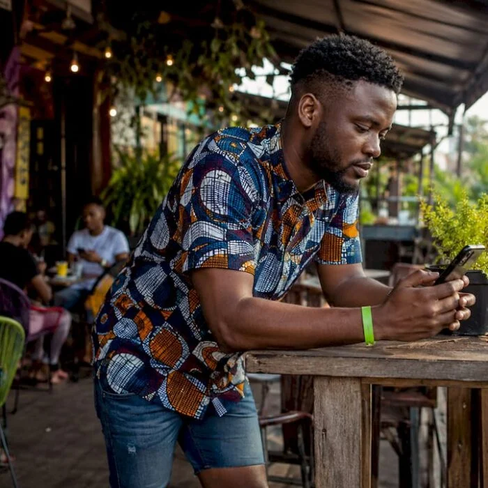 Man checking entertainment updates on phone at market