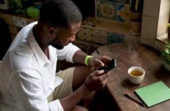 Man dialing USSD code on smartphone at home