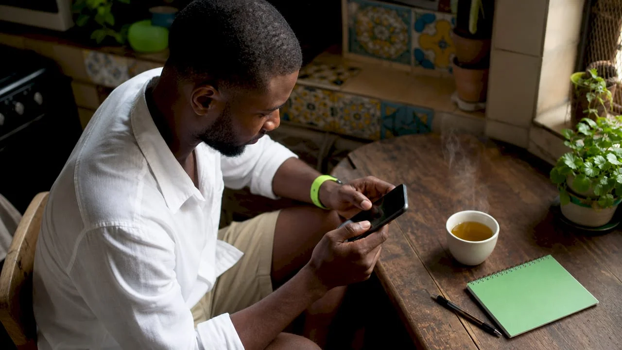 How to Verify NIN in Nigeria: 2026 Step-by-Step Guide 1 Man dialing USSD code on smartphone at home