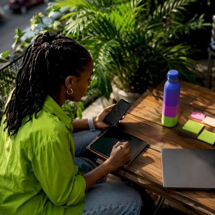 Marketer using tablet and phone at desk