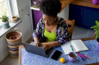 Nigerian woman typing blog setup at home office desk