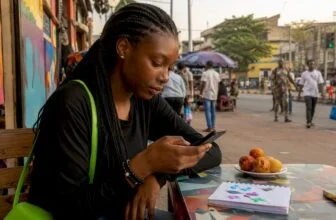 Nigerian woman typing shareable forum post on phone