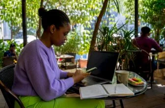 Woman entering IMEI data on laptop
