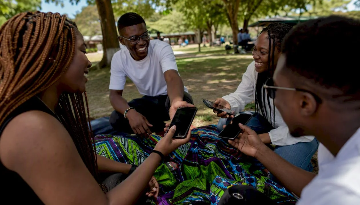Hands exchanging smartphones outdoors