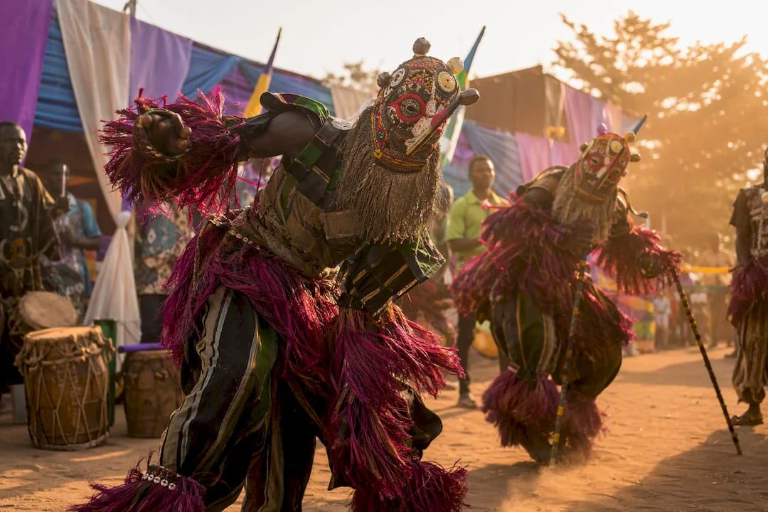 Masquerade performers in colorful Nigerian festival costumes