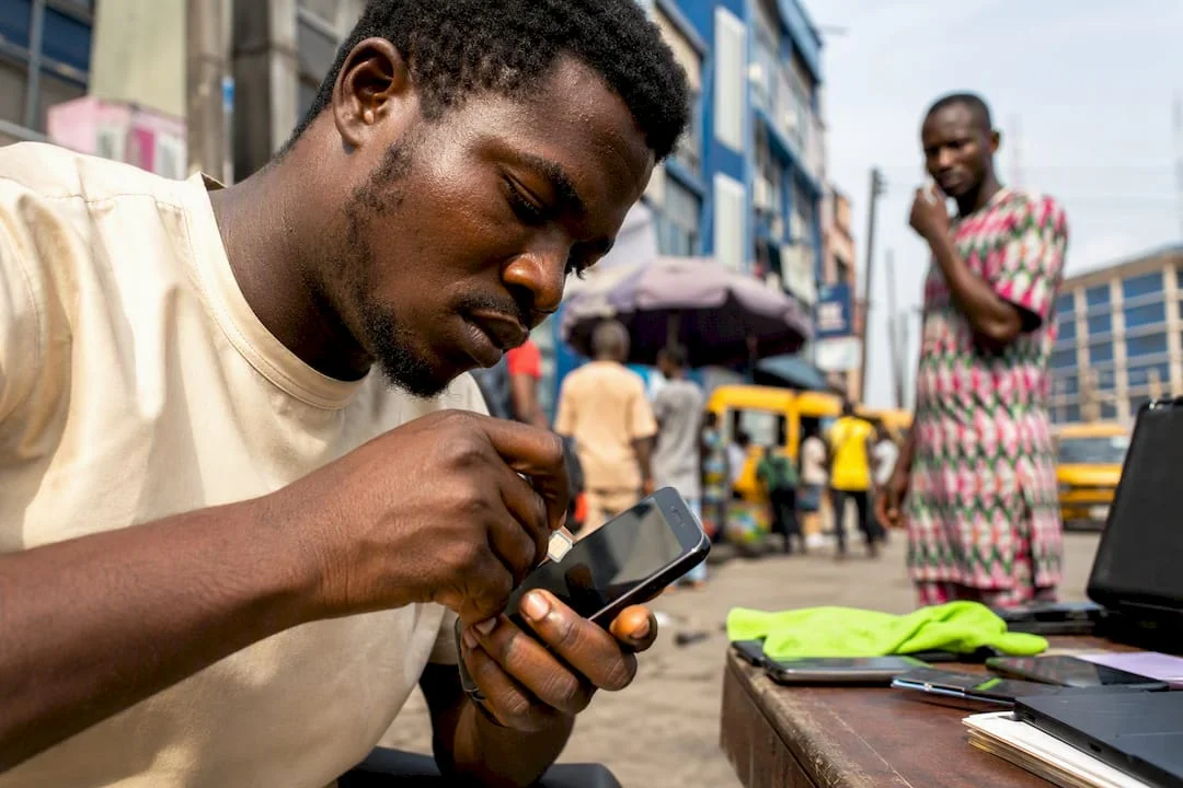 Street vendor inserting SIM card into phone
