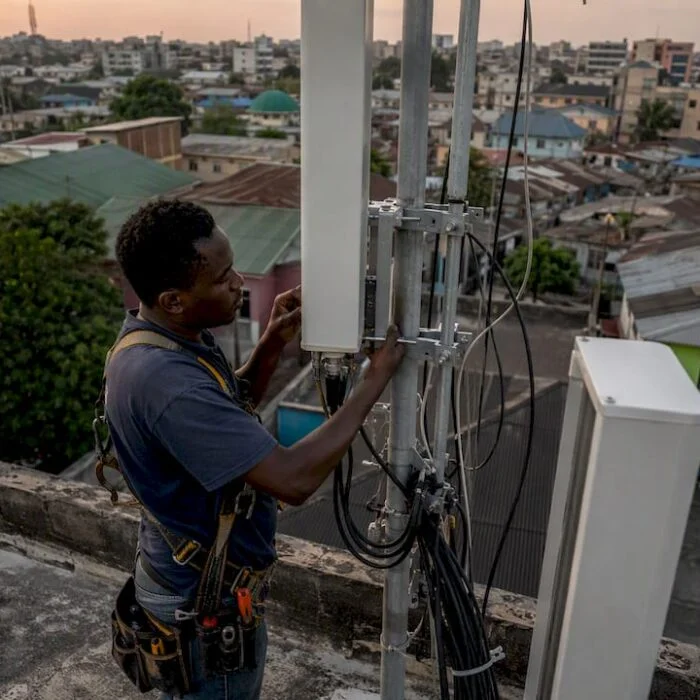Technician installing 4G antenna in Nigerian city