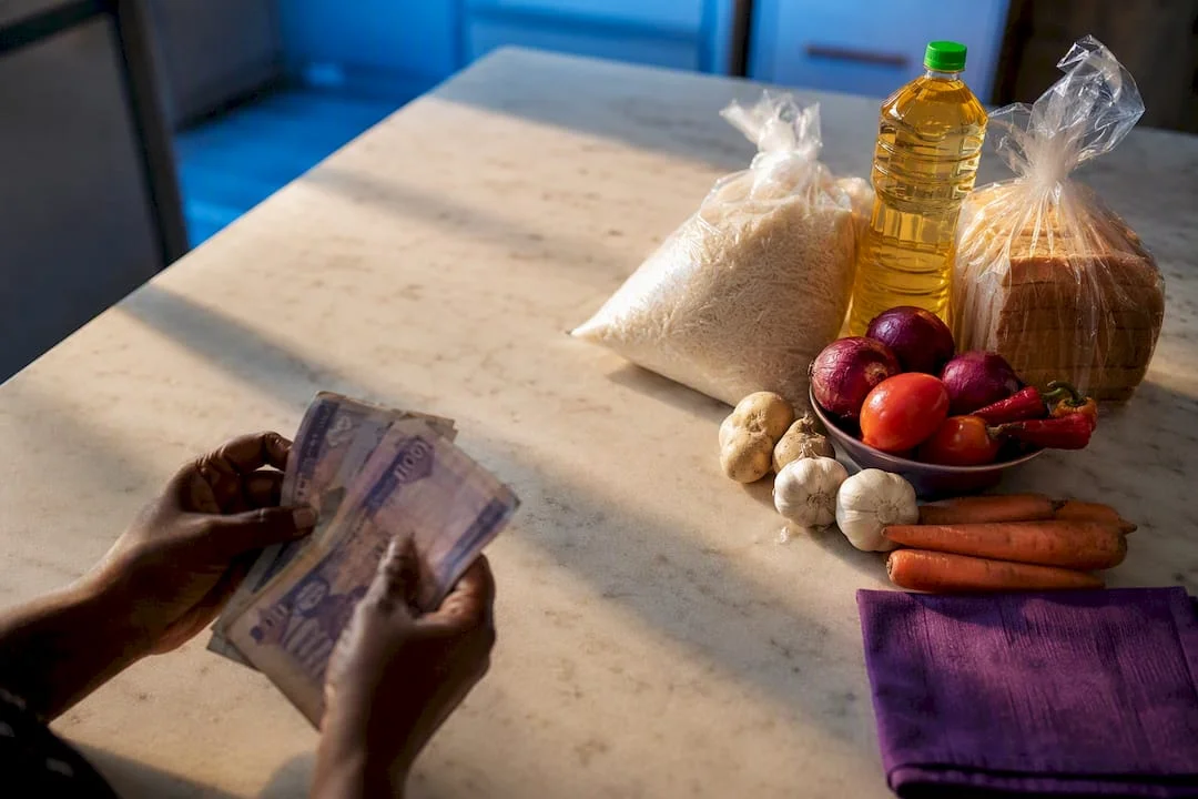 ₦70,000 (≈$51) in 2026: What Nigeria's Minimum Wage Actually Pays For 1 Naira notes beside everyday household staples