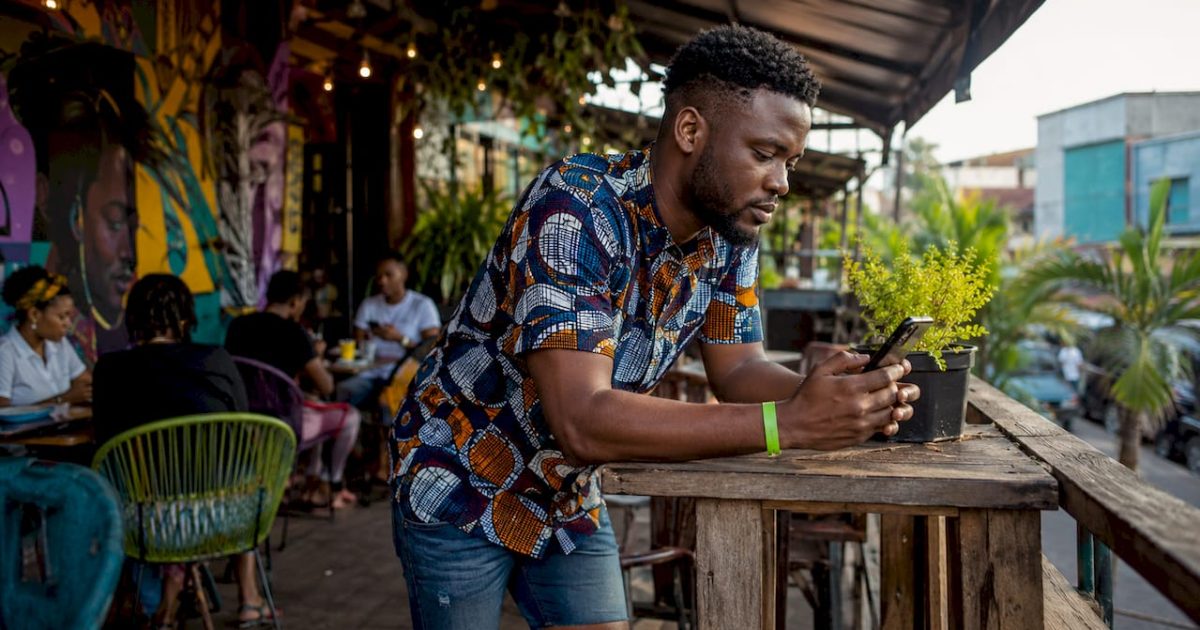 Man checking entertainment updates on phone at market